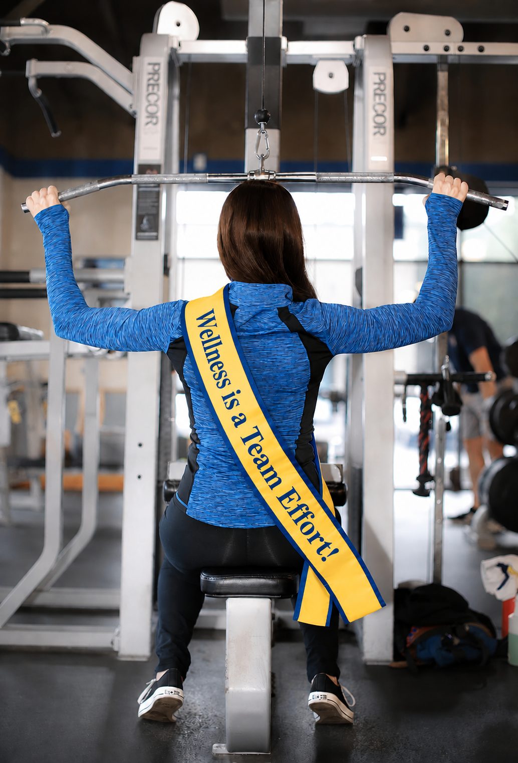 Athlete training with a Team Wellness sash that reads Wellness is a Team Effort